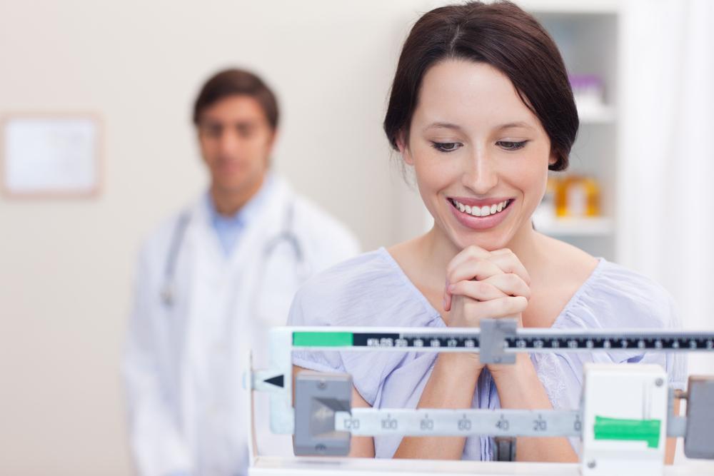 Woman standing on a scale after losing weight 